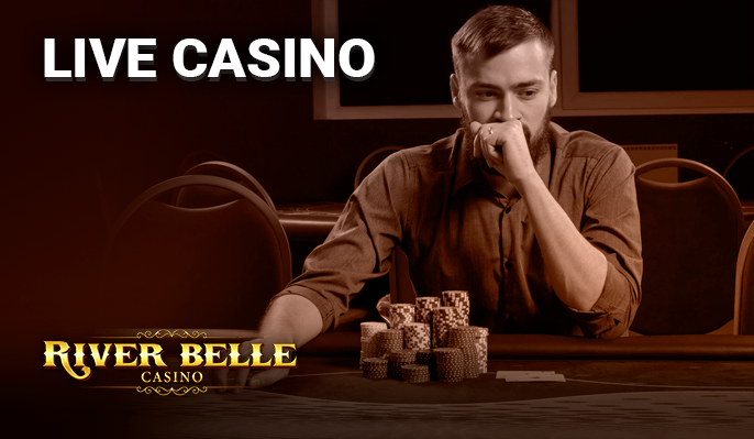 A man sitting at a poker table with a mountain of gambling chips and the River Belle Casino logo